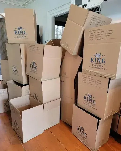 King Affordable Movers' crew holding a box with contact details