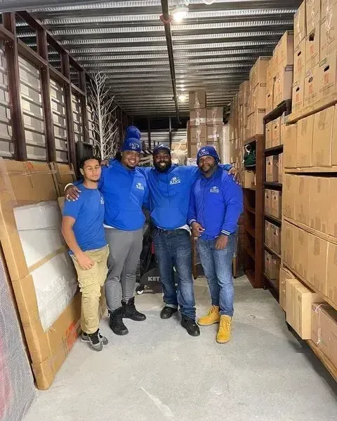 Two King Affordable Movers' crew packing up some tables in a room