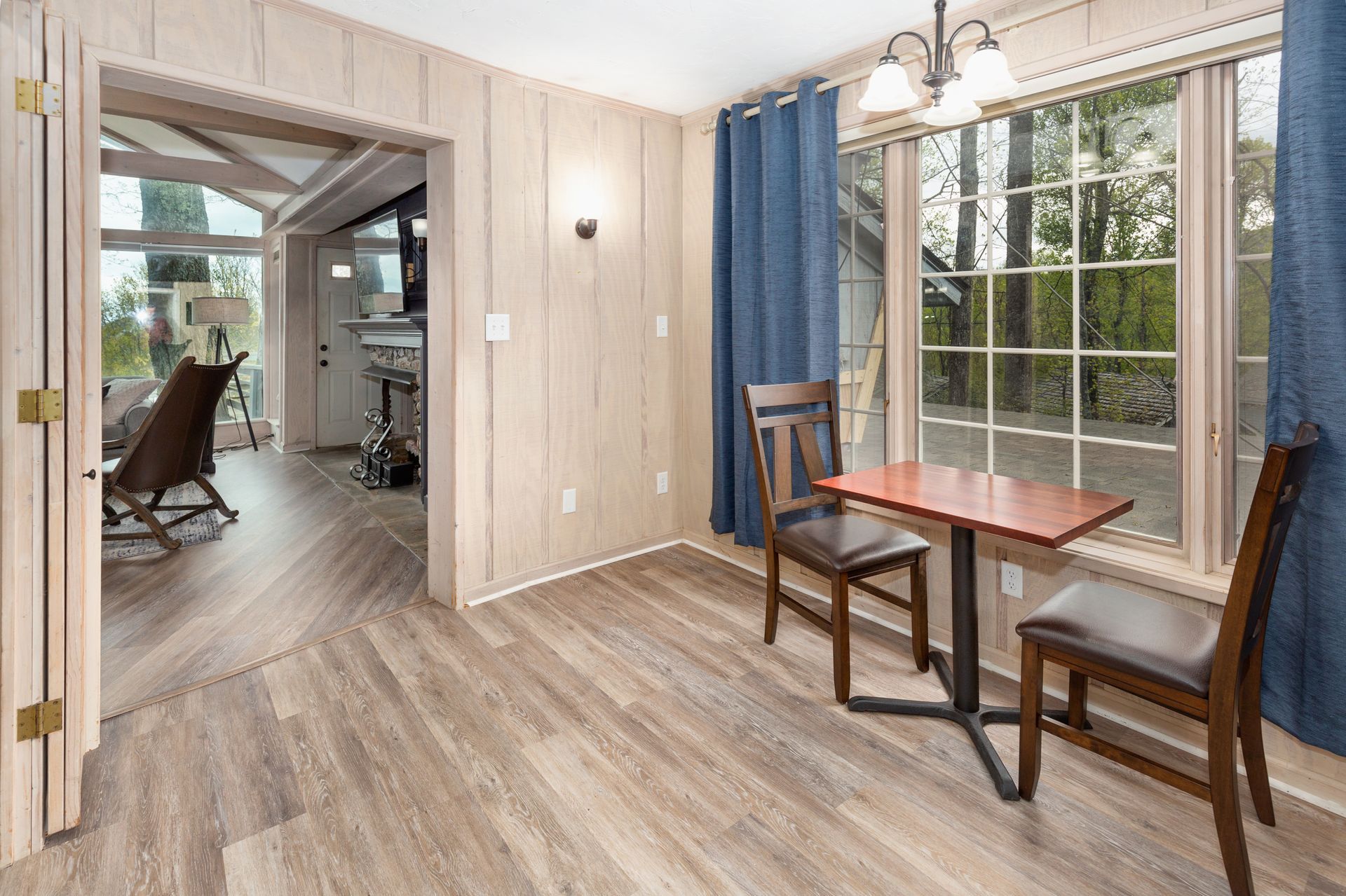 A living room with a table and chairs in front of a window.
