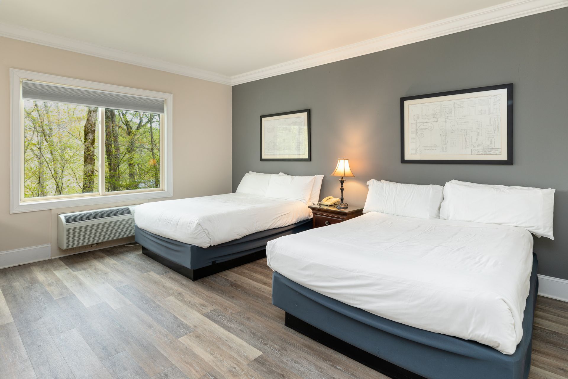 A hotel room with two beds and a large window.