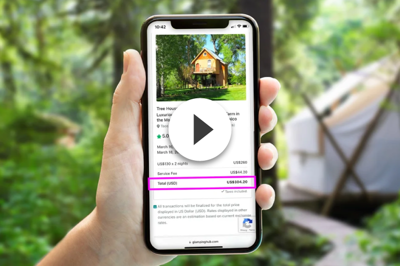 A person is holding a cell phone with a picture of a house on the screen.