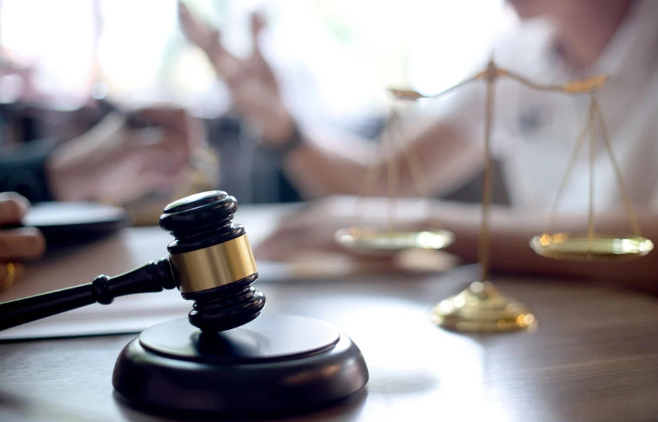 A judge 's gavel and scales of justice are on a table.