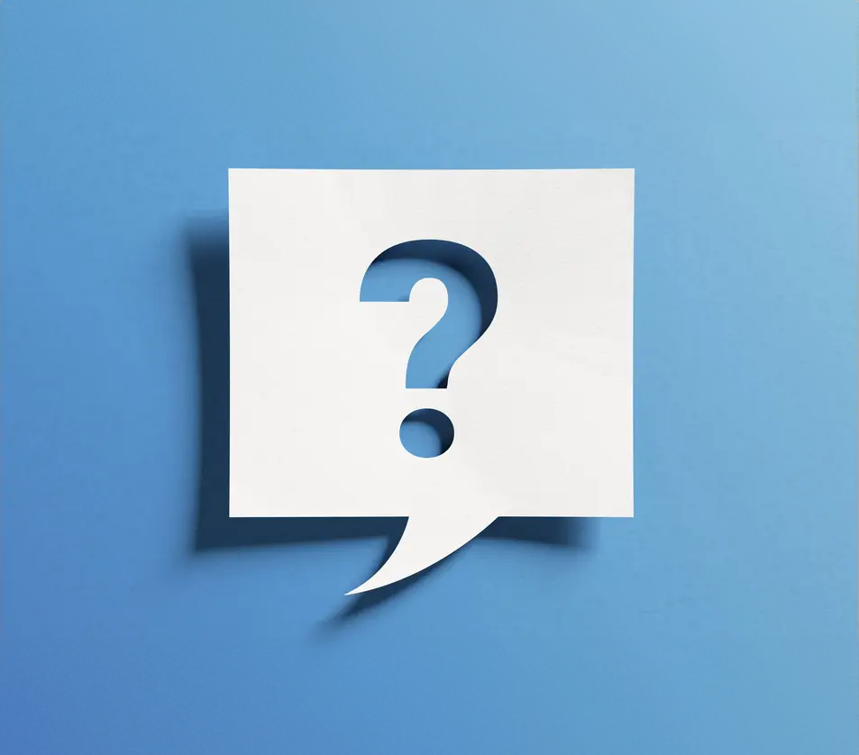 A paper speech bubble with a question mark cut out of it.