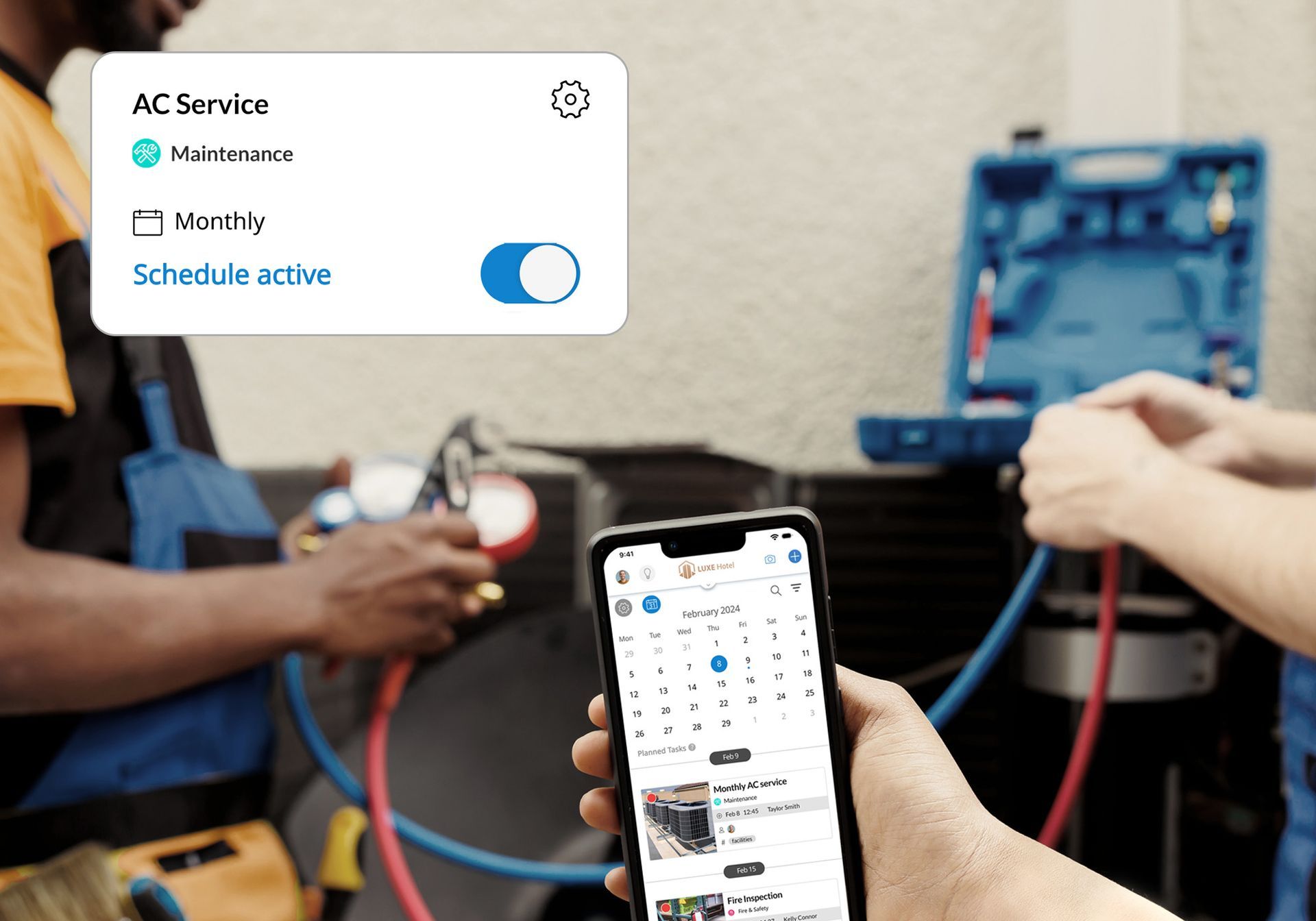 A person is holding a cell phone in front of a man working on a machine.