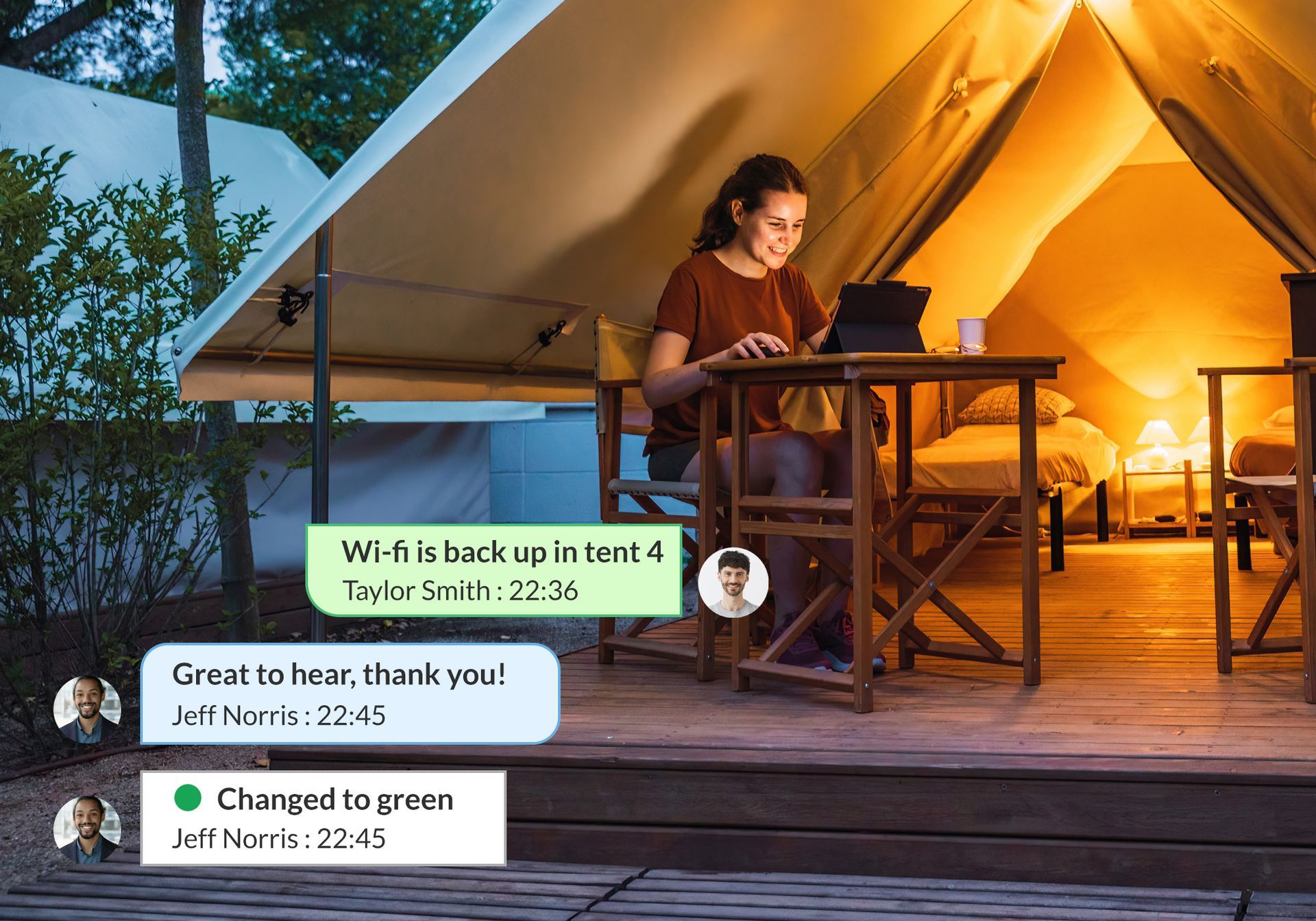 A woman is sitting outside of a tent using a tablet computer.