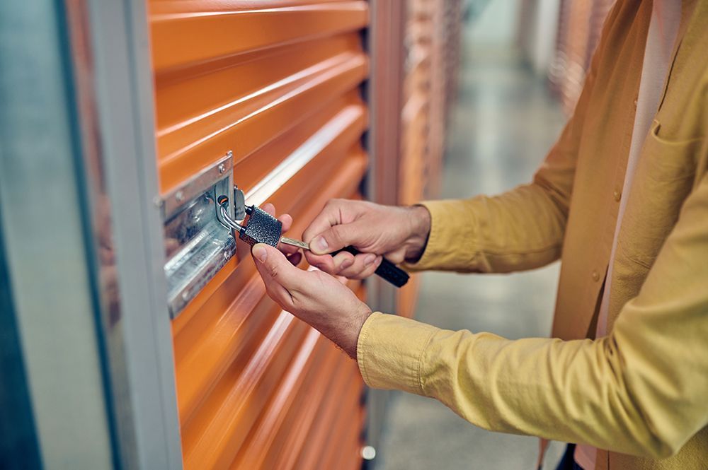 Worker padlocking the door of the storage unit
