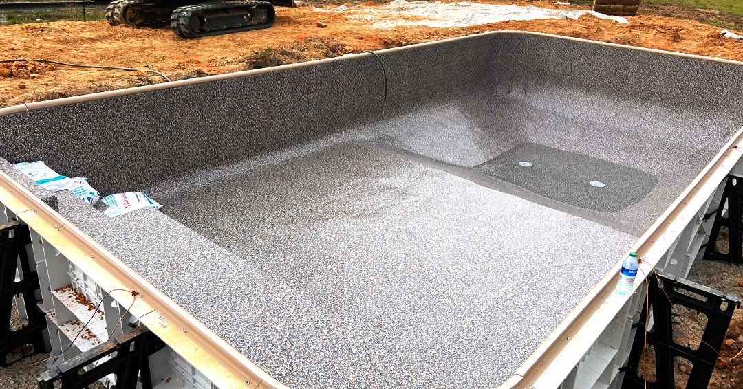 Large gray speckled sink basin installed on a countertop in a workshop or kitchen setting.