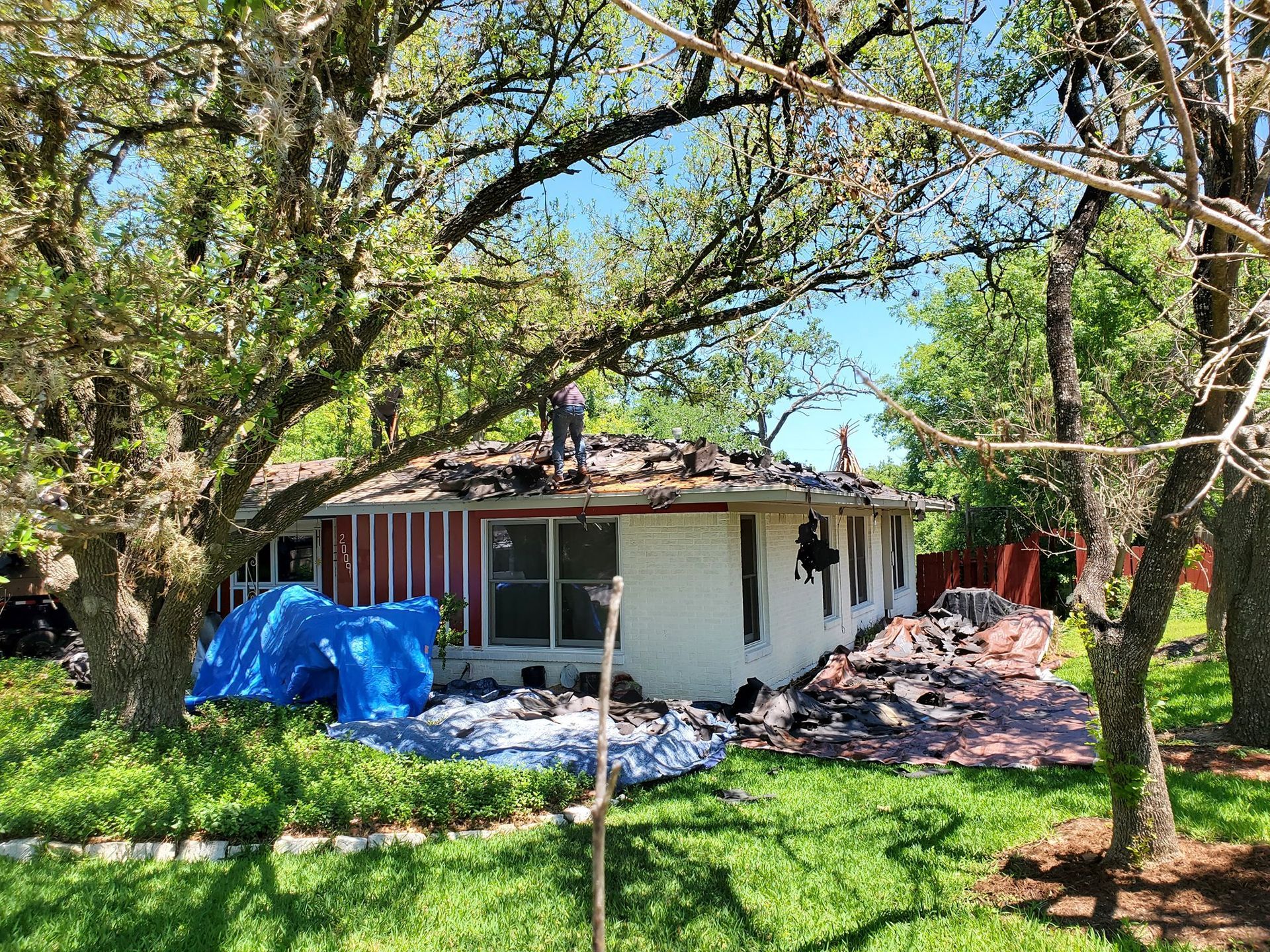 A house is being demolished in the middle of a lush green field.