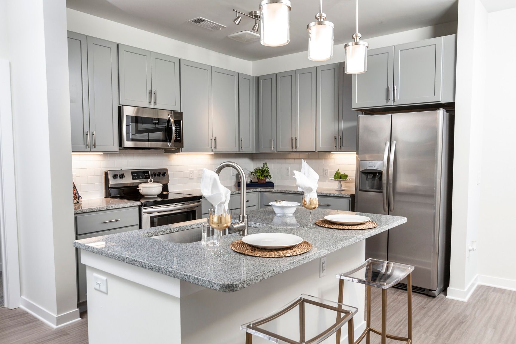 A man wearing a hard hat and gloves is working on an electrical box.