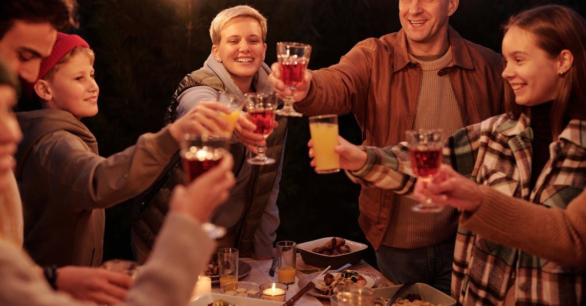 a group of people are sitting at a table talking to each other .