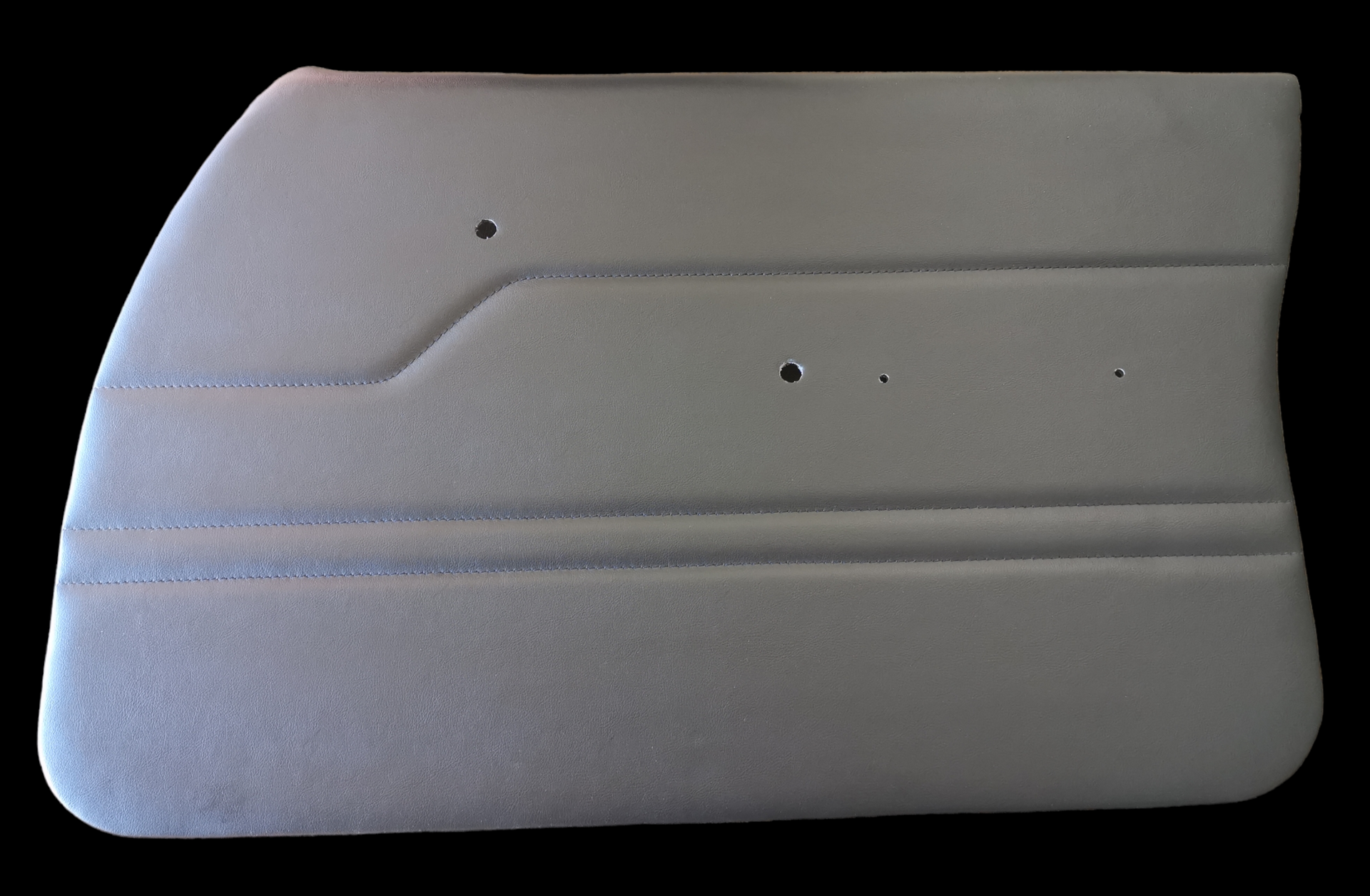 Light gray car door panel with textured surface, horizontal lines and several holes.