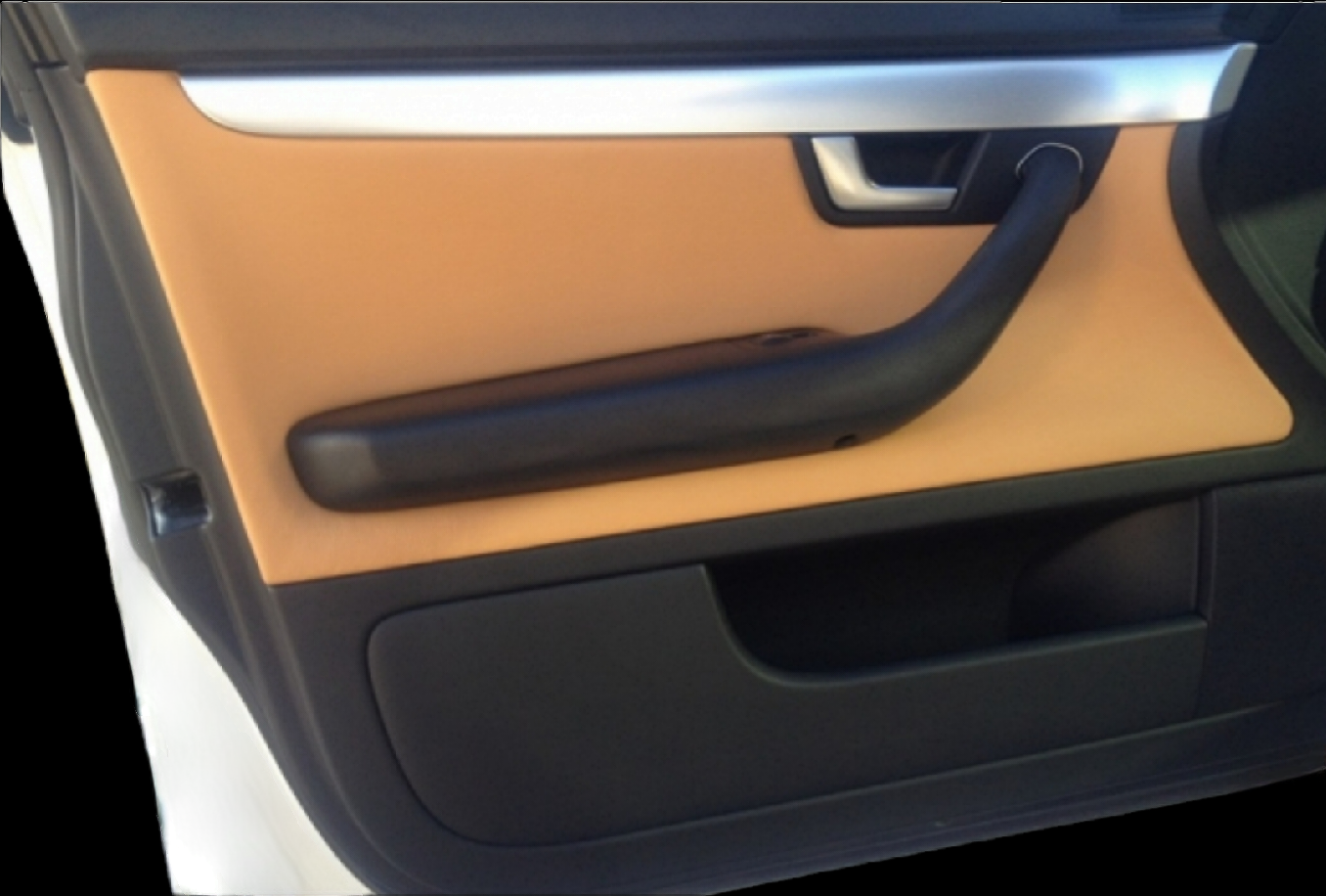 Car door panel: Tan and black interior with a black armrest and silver handle trim.
