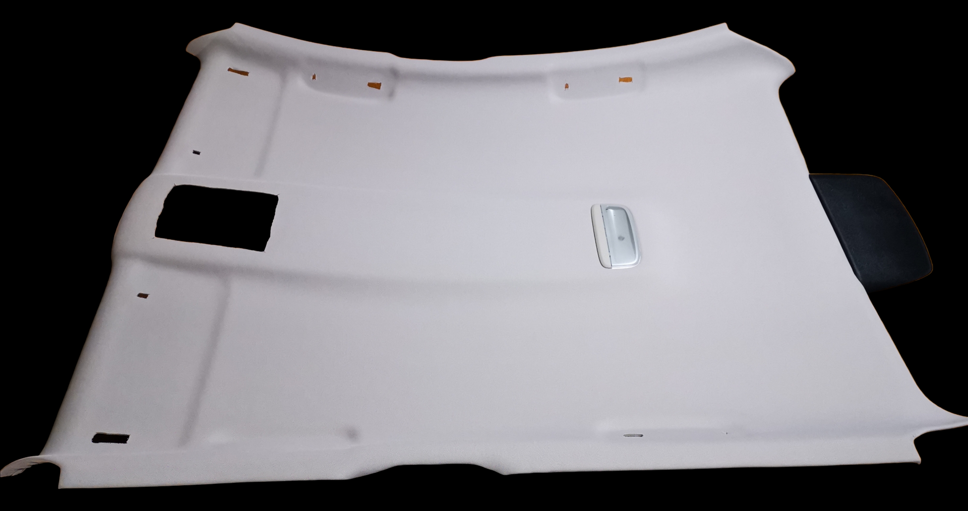 White car headliner with a rectangular opening and a silver light fixture.
