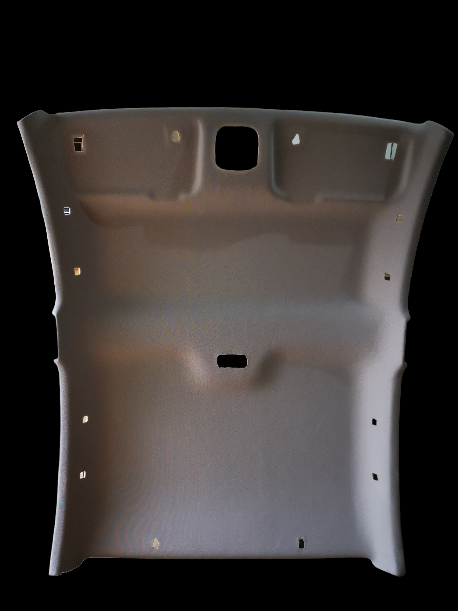 Gray car headliner with various holes.