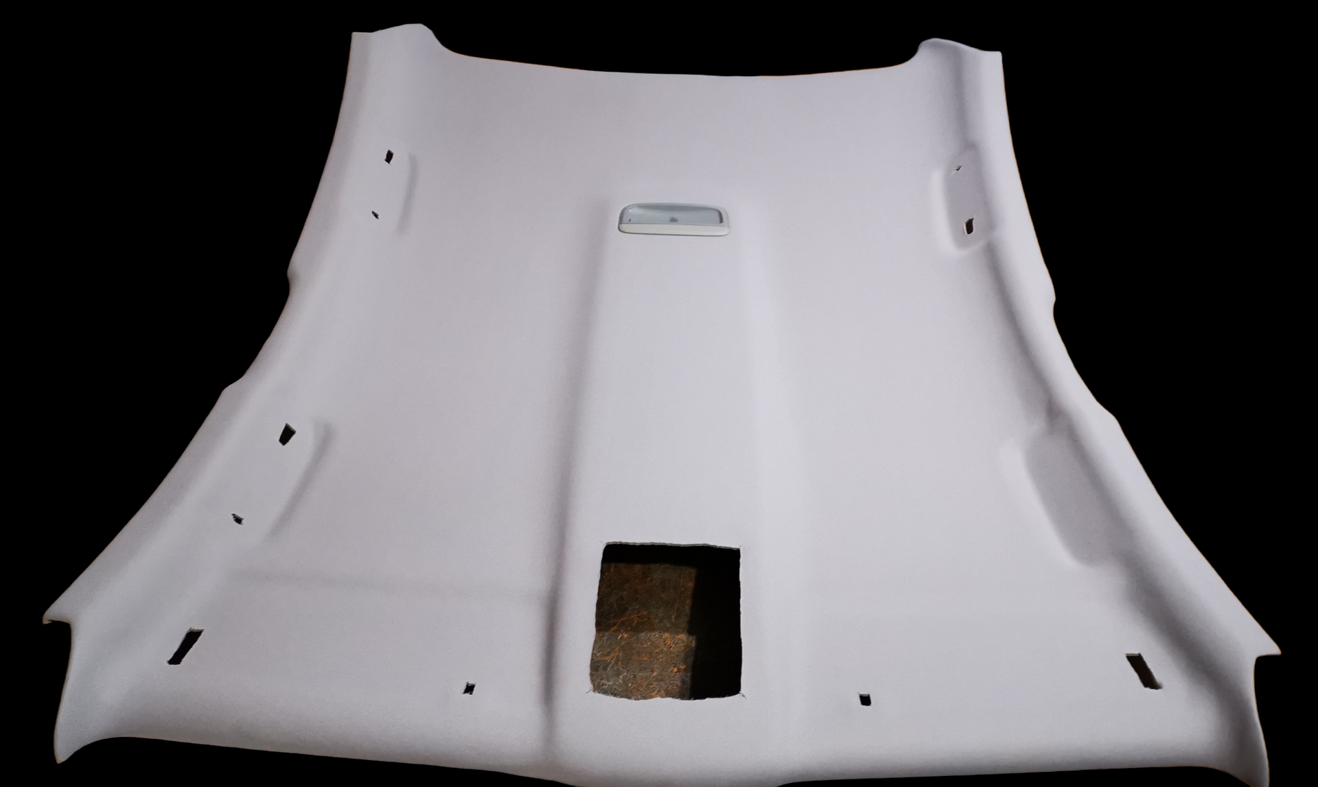 White car headliner with openings for sun roof and light fixtures.