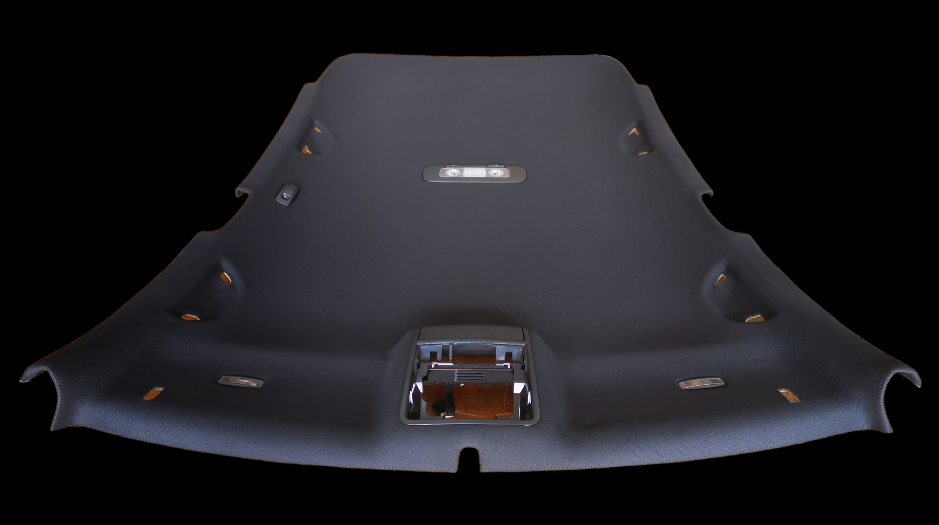 Black car headliner with various holes for lights and other components.