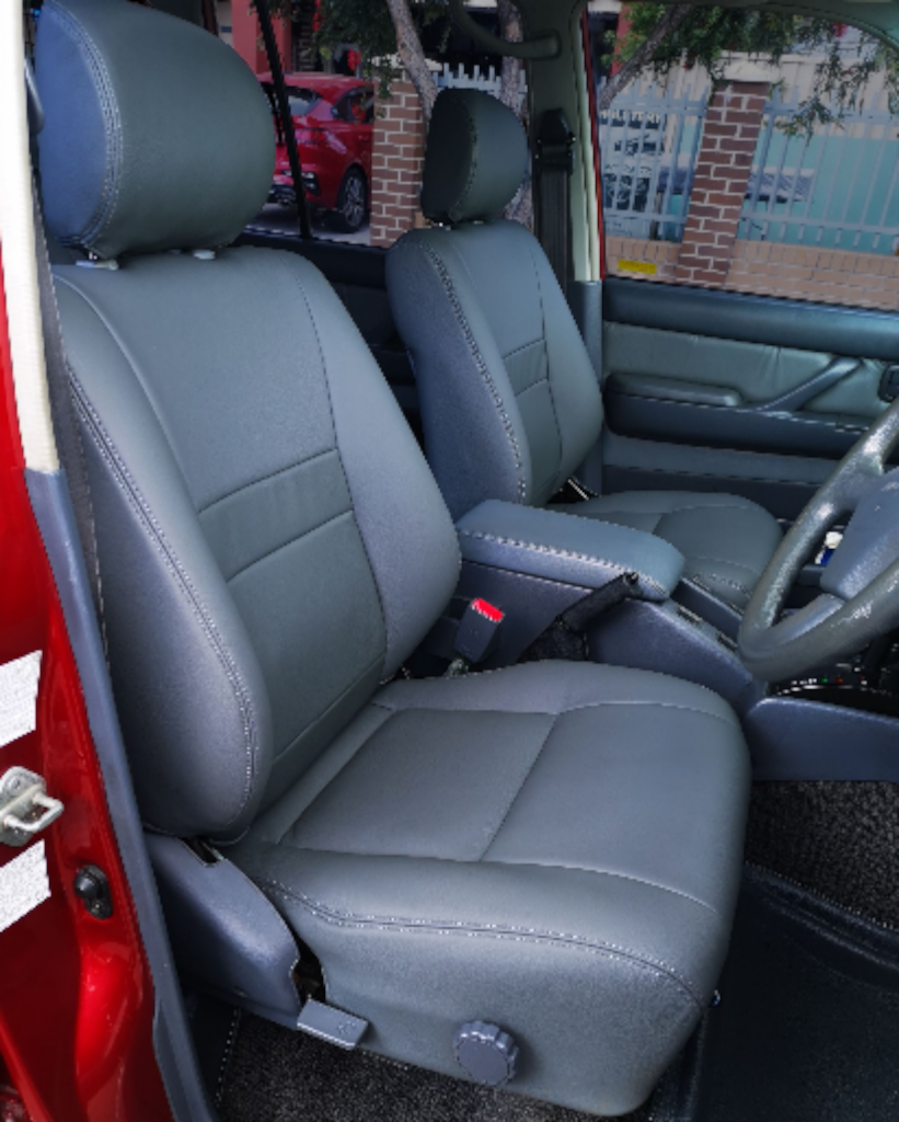 Gray leather car seats inside a red vehicle.