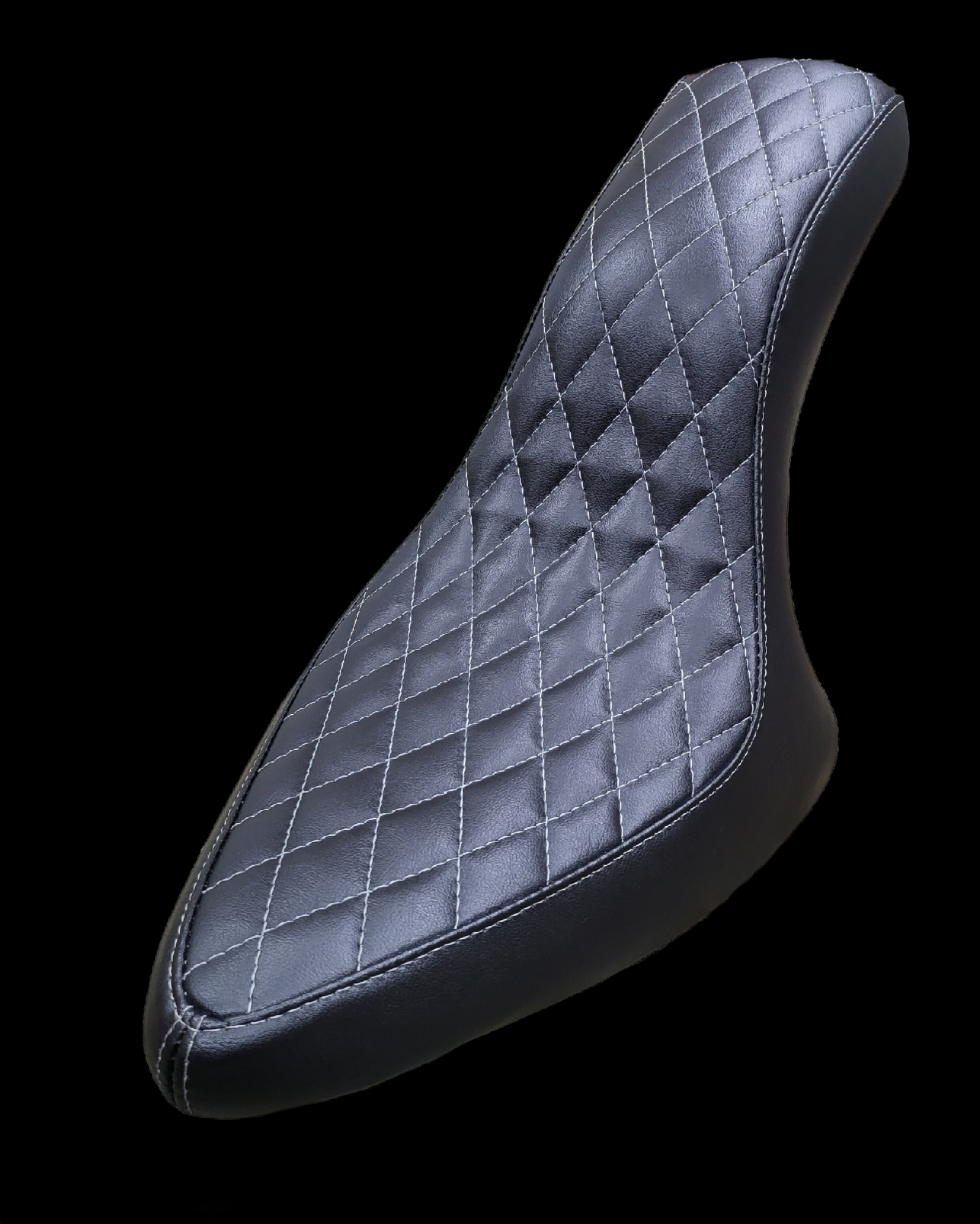 Black motorcycle seat with diamond stitching, white thread.