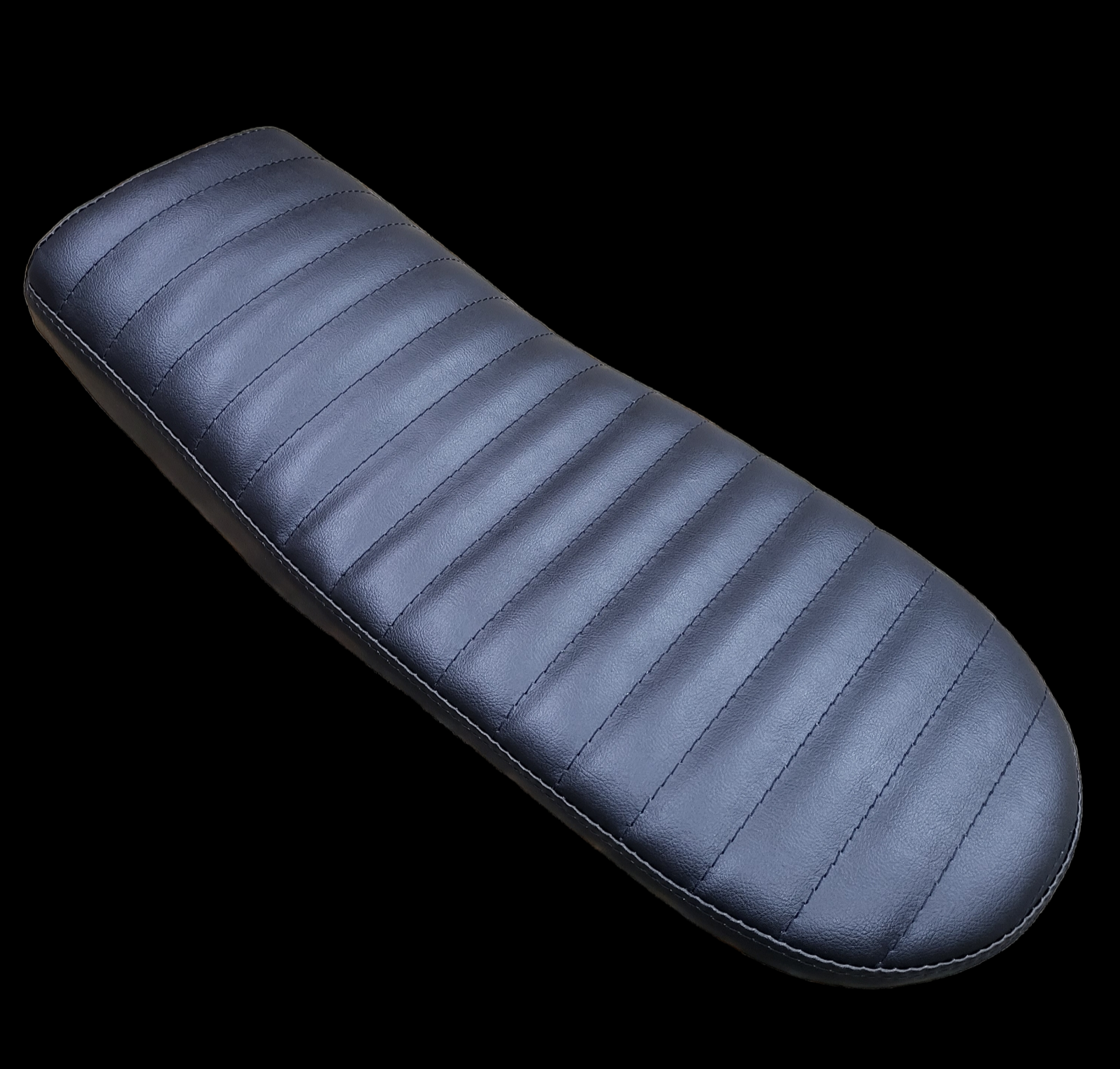 Dark blue motorcycle seat with horizontal stitching on a black background.