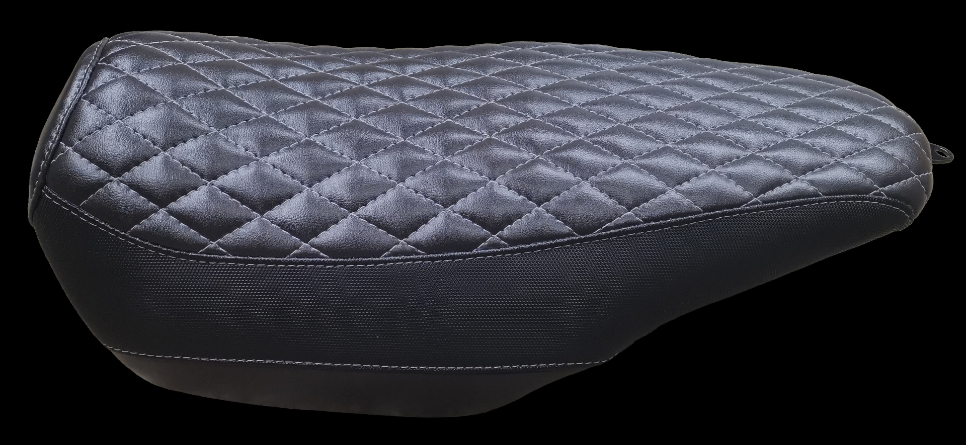 Black diamond-stitched motorcycle seat against a black background.