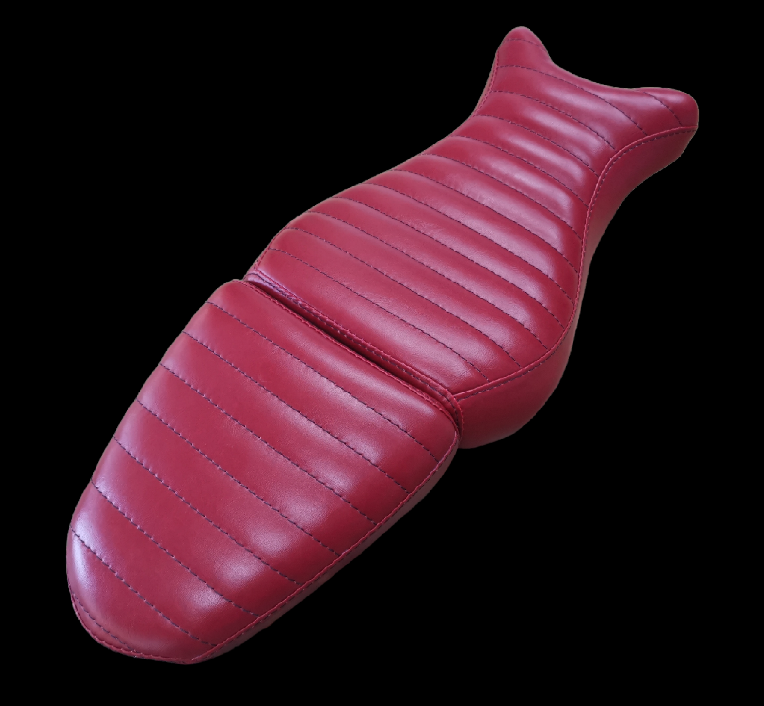 Red motorcycle seat with a ribbed design on a black background.