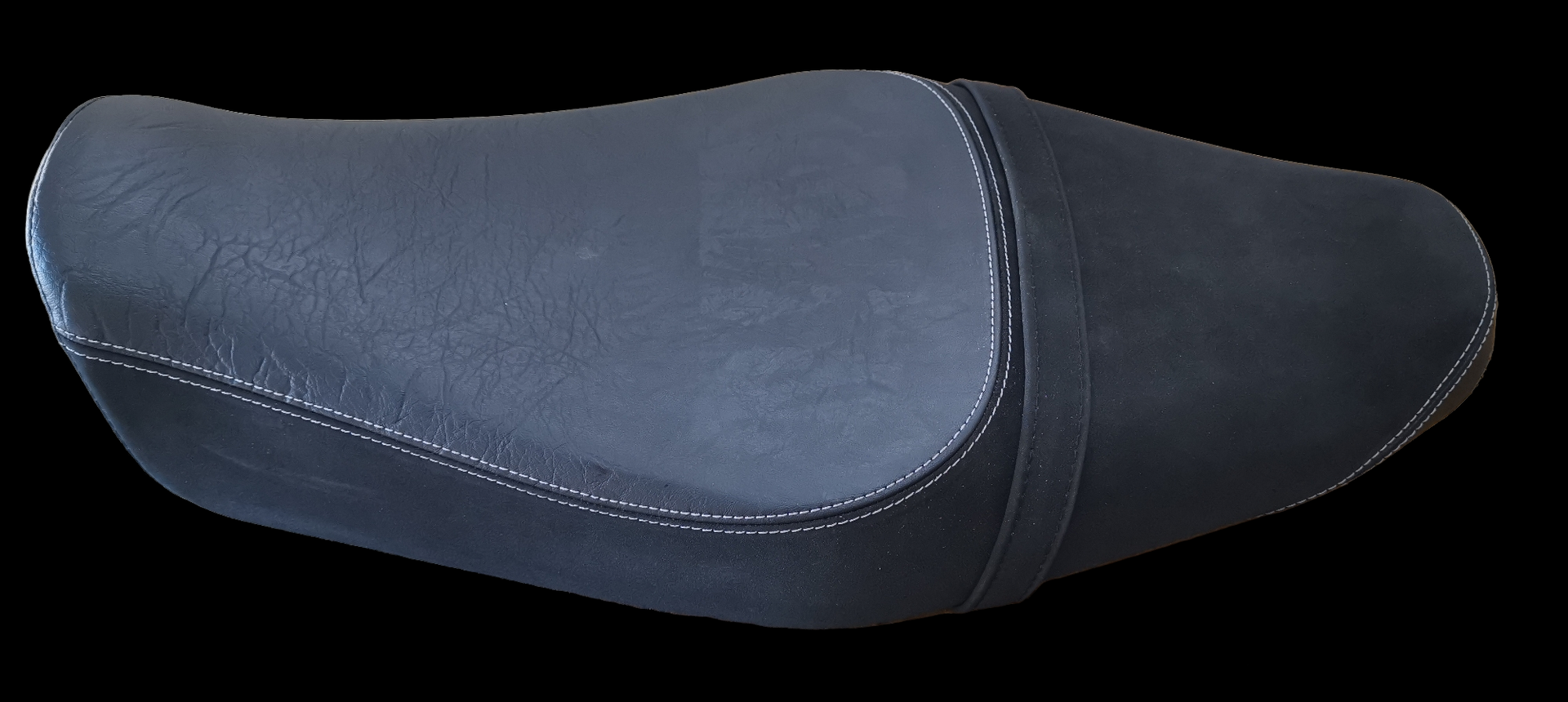 Black motorcycle seat with white stitching.