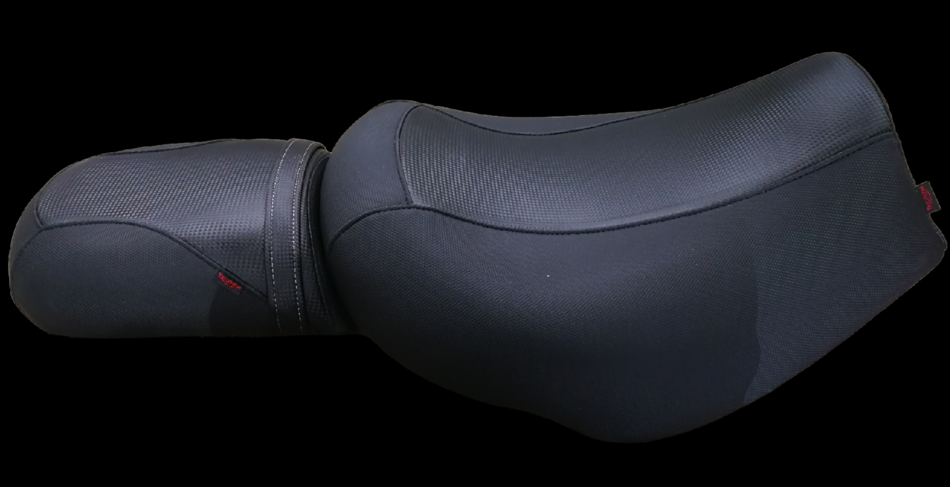 Black motorcycle seat with a textured surface, designed for comfort, on black background.