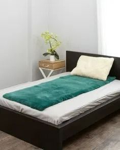 a Bed With a Green Faux Fur Mat and a White Pillow — Ballina Home Healthcare Sales & Hire and Compression Stockings Plus in Ballina, NSW