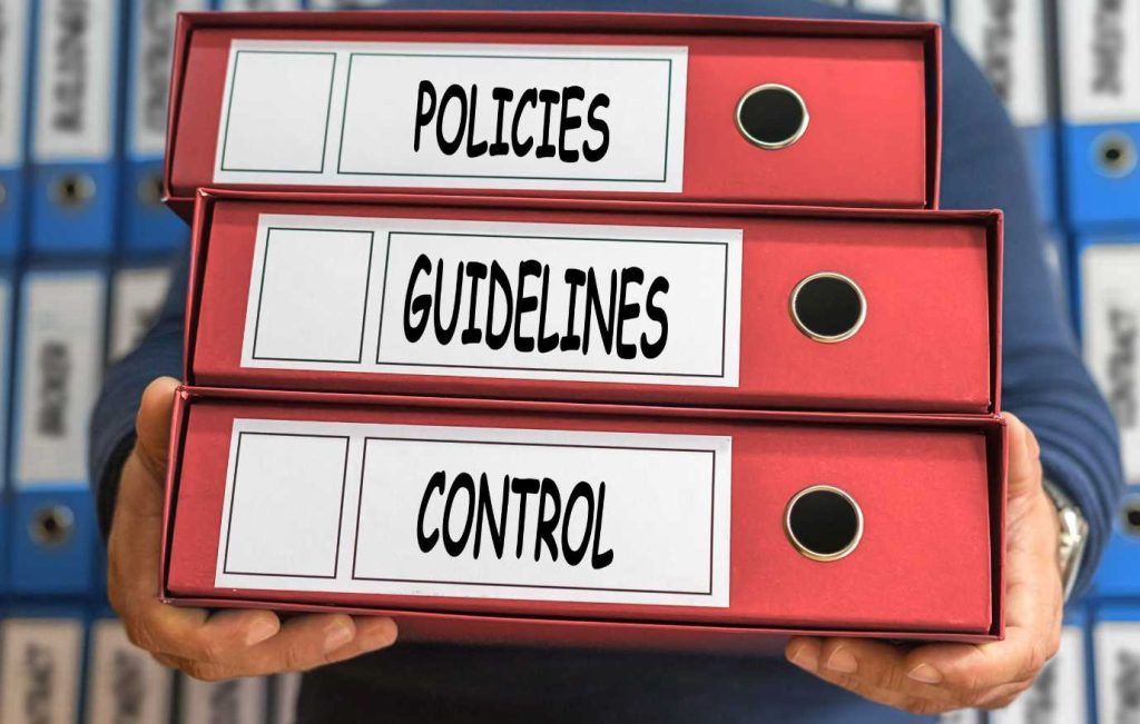 Person holding red binders labeled 