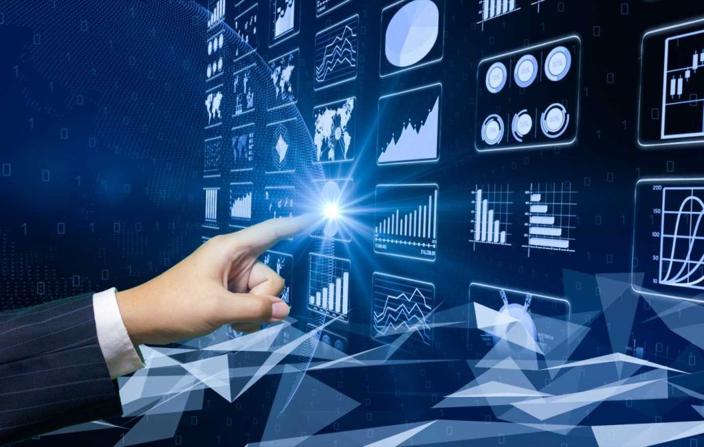 Hand touching a glowing screen with charts and graphs, a digital interface.
