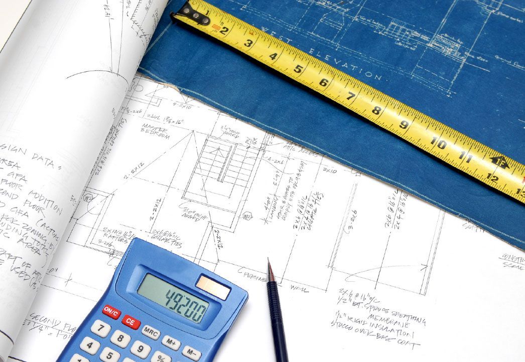 Blueprints, calculator showing 49,200, measuring tape, and pen on a table.