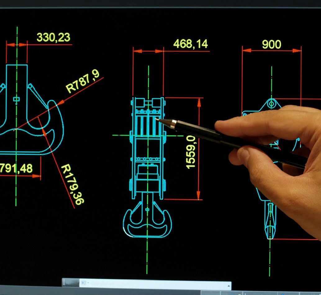 A hand holding a stylus points to a technical drawing of machinery on a digital screen, using blue lines and dimensions.