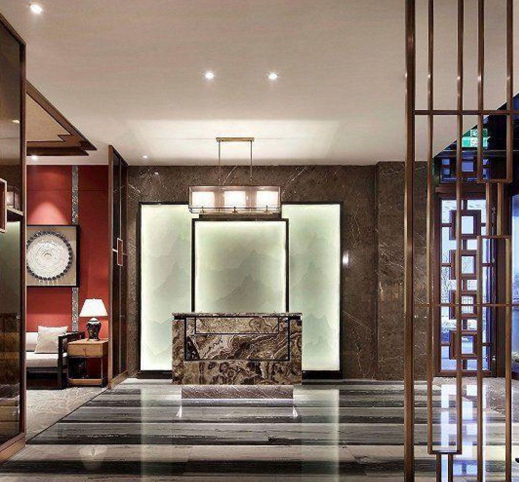Luxurious lobby with marble reception desk, glowing green accent, and gold metal accents.