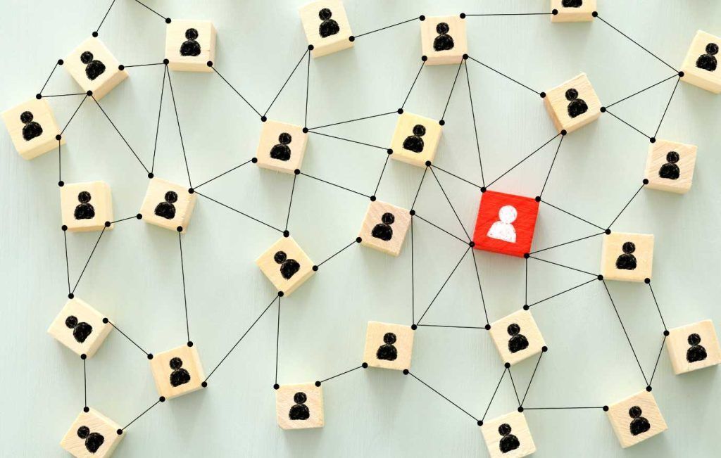 Network of linked blocks, most tan, one red, each with a person icon.