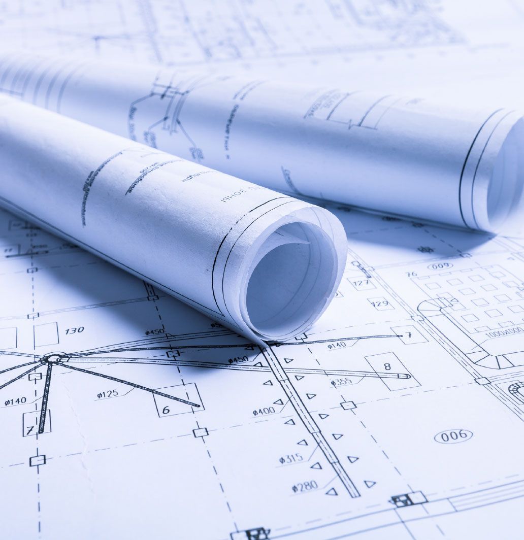Two rolled-up blueprints lying on top of a detailed architectural plan, with a blue tint.