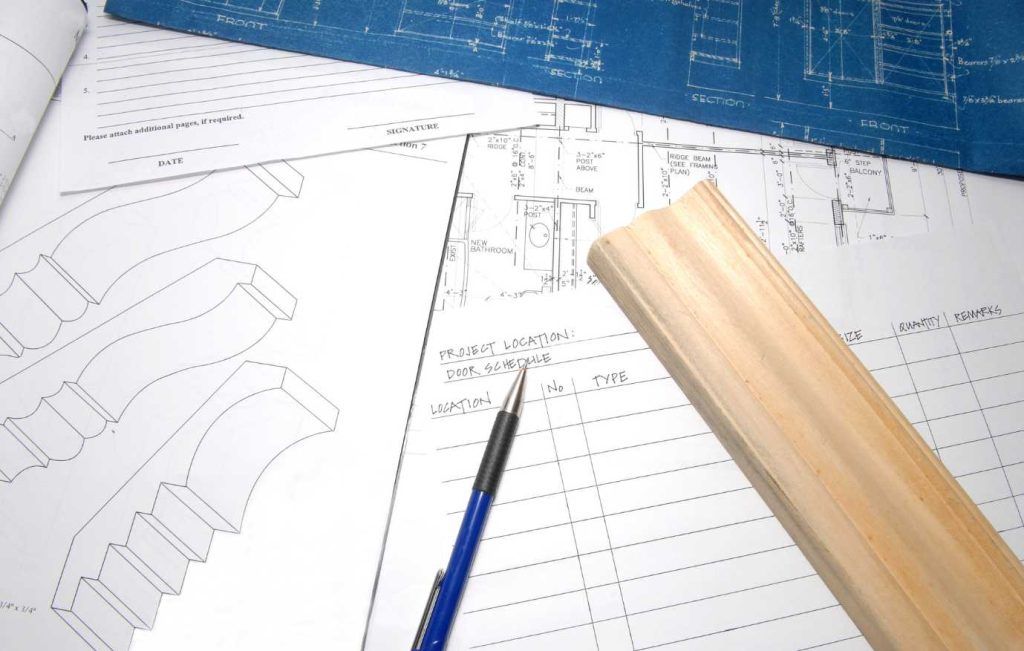Blue architectural blueprints with a pencil and wooden plank.