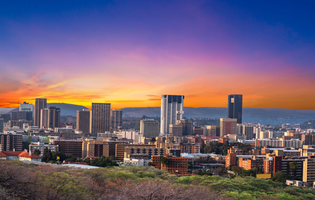 City skyline at sunset with orange and purple sky, buildings in South Africa.
