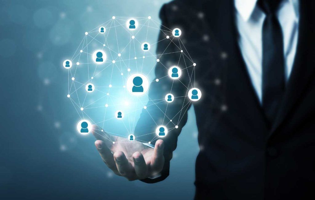 Businessman holding glowing network of connected people.
