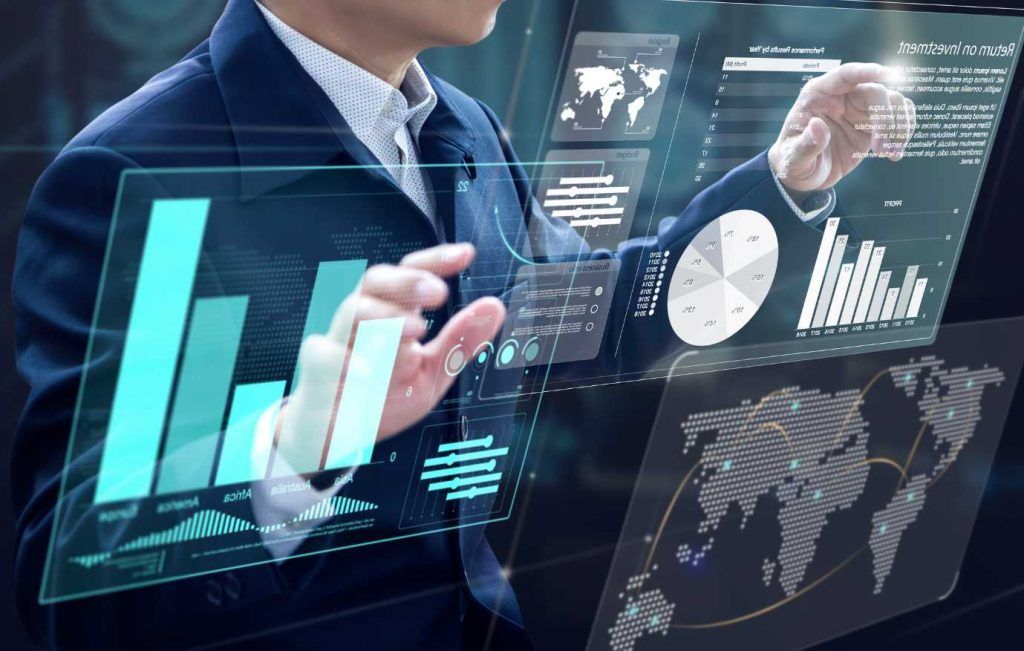 Person interacting with holographic data visualizations, including charts and maps.