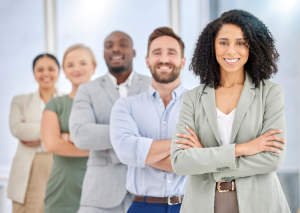 Team of diverse professionals standing with arms crossed, smiling at the camera.