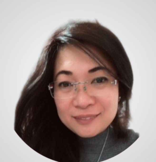 Woman with dark hair and glasses smiling.