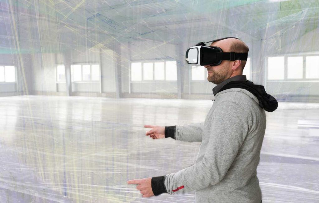 Man wearing VR headset, pointing in a large, empty room with overlaid digital lines.