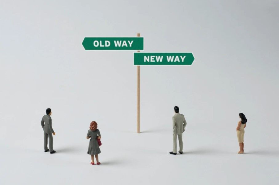 Miniature figures look at a signpost pointing 