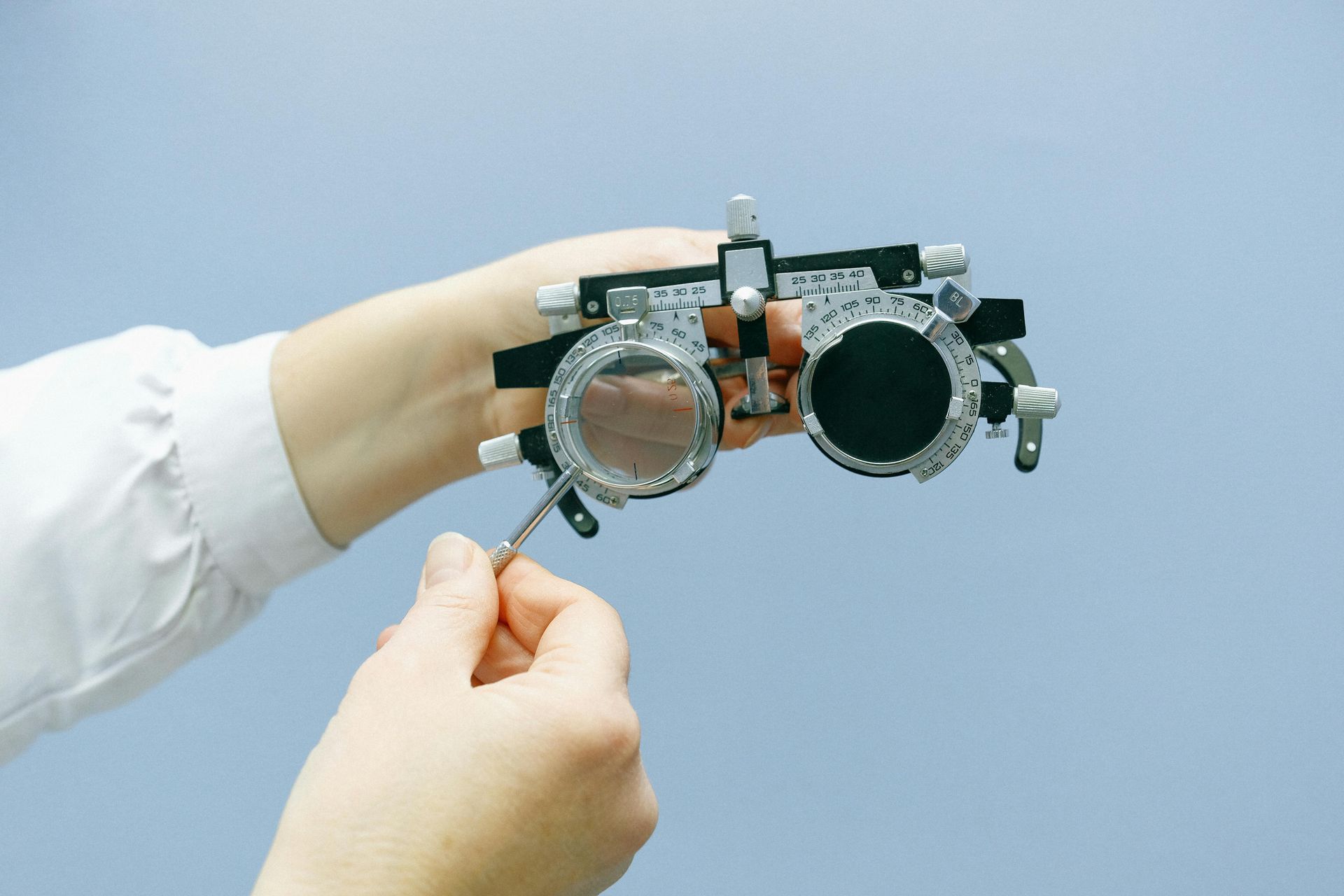 A person is holding a pair of glasses in their hands.