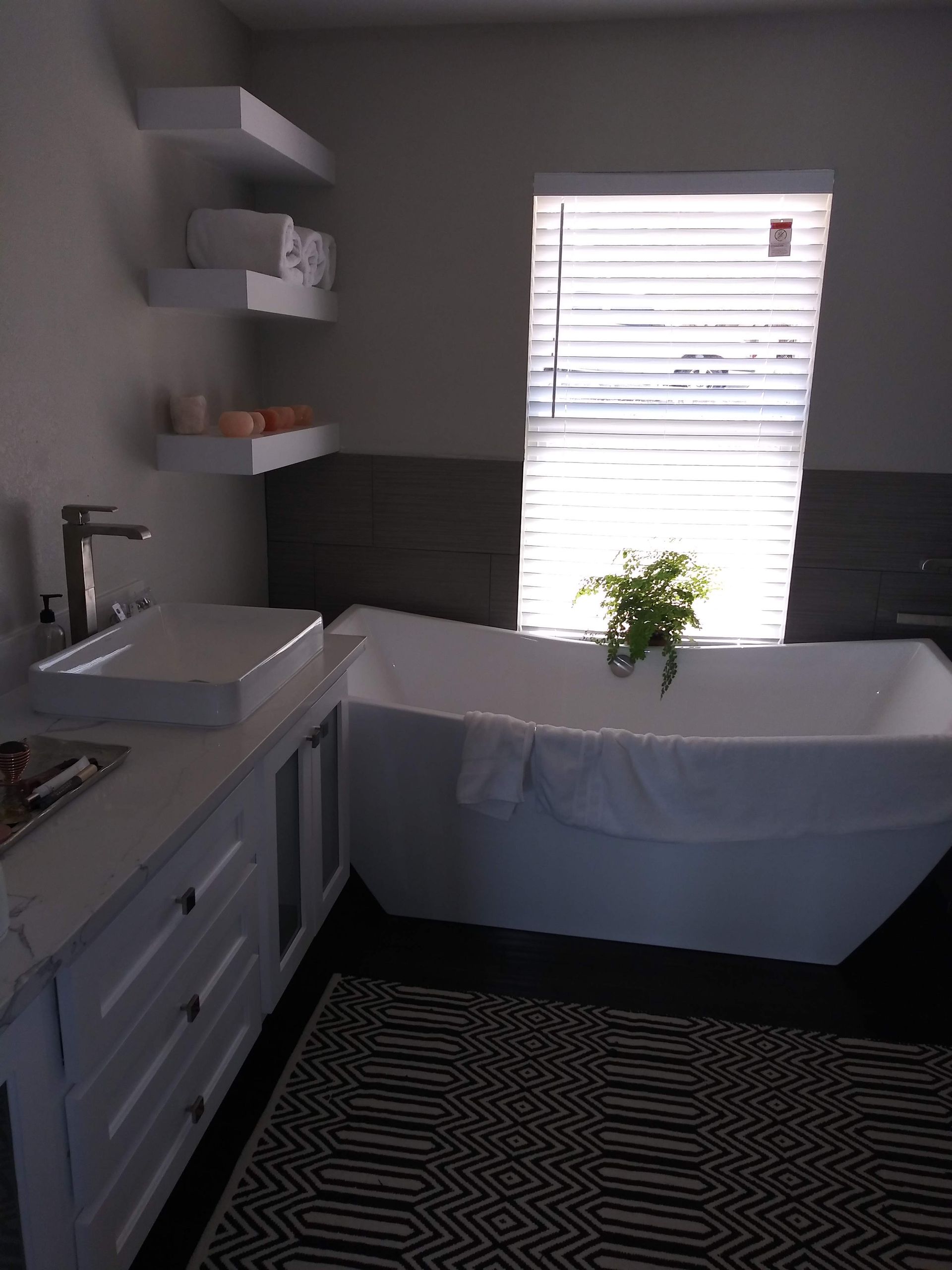 A bathroom with a tub a sink and a window