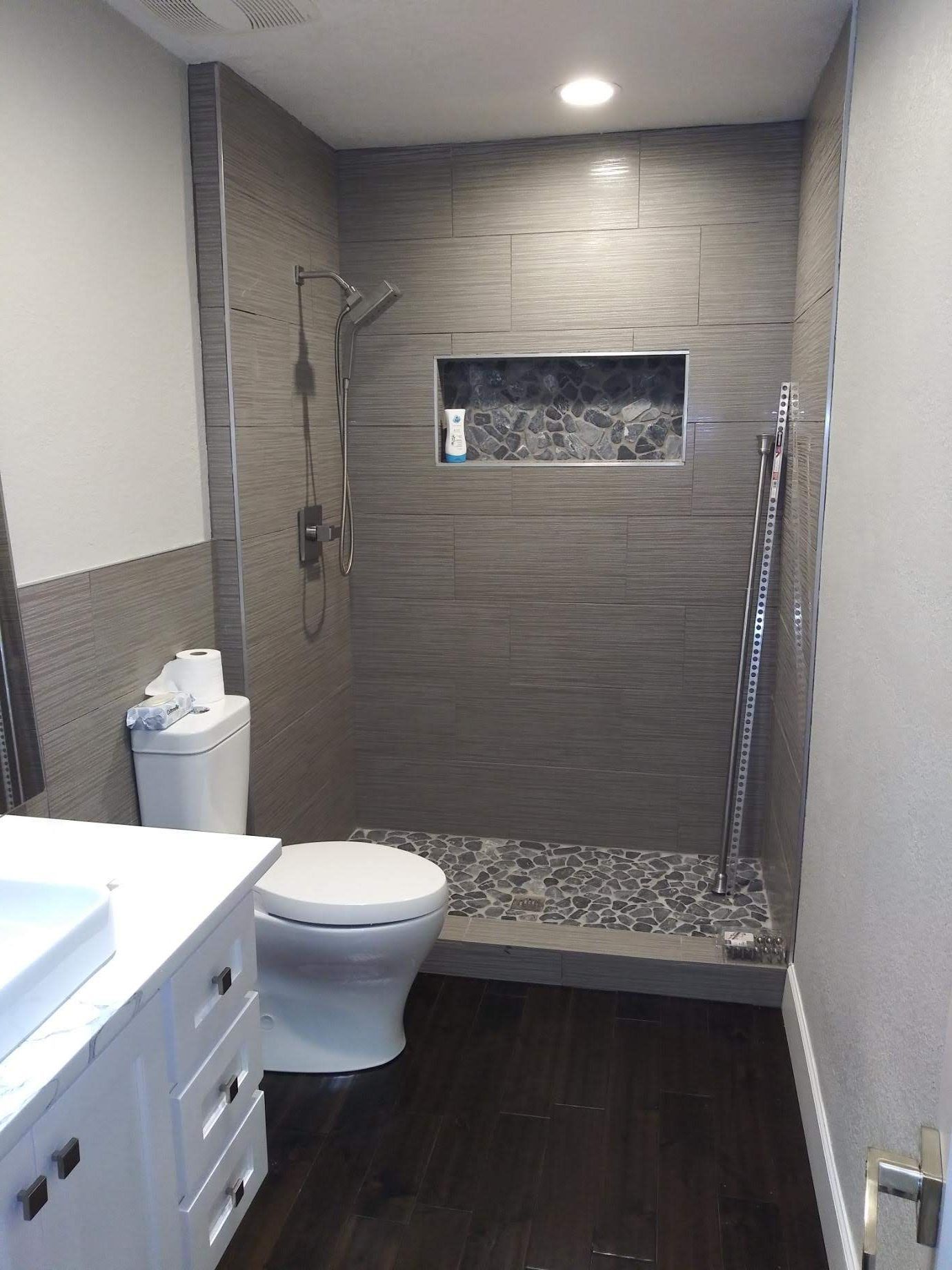 A bathroom with a toilet , sink and walk in shower.