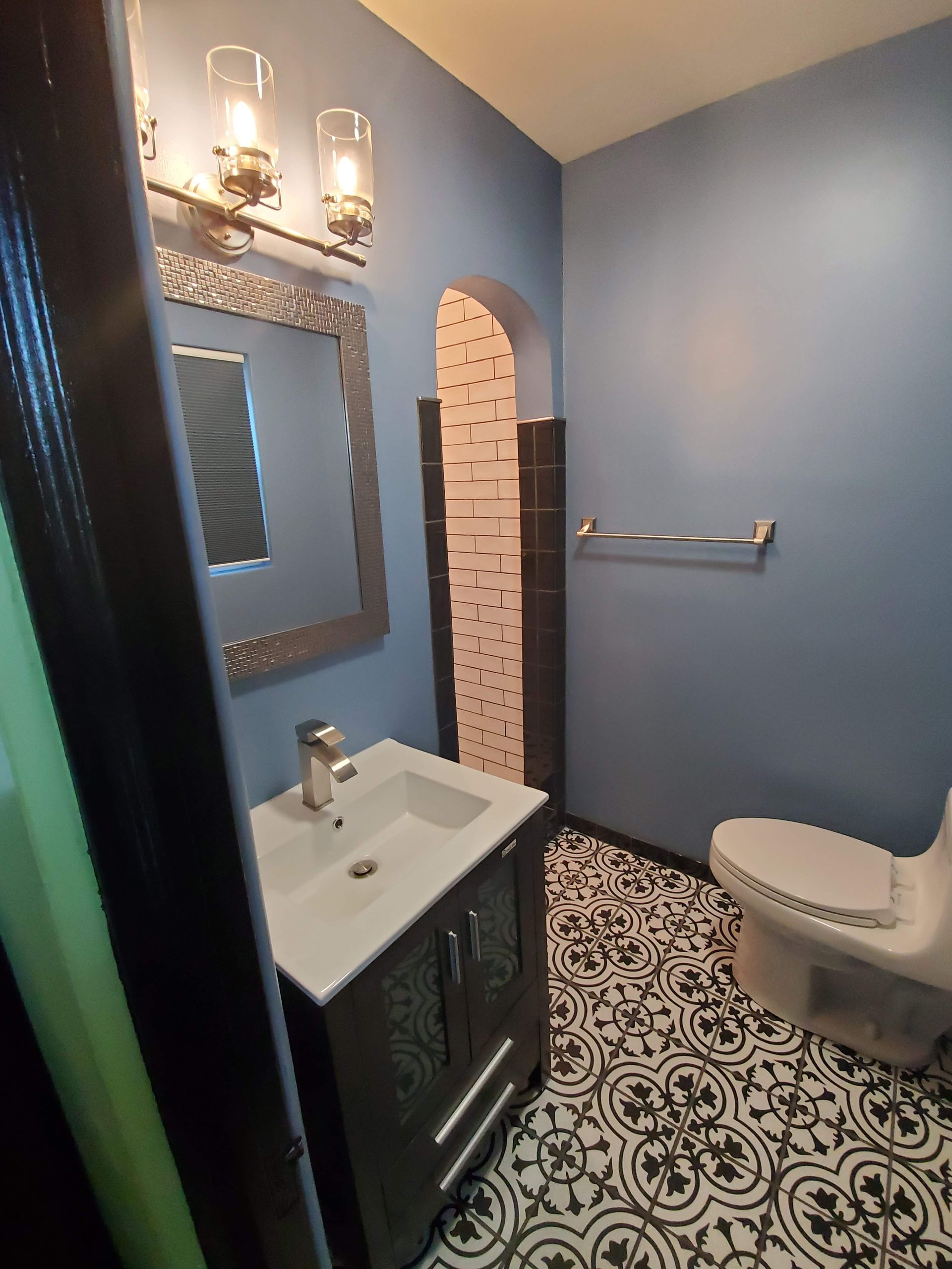 A bathroom with a sink , toilet and mirror.