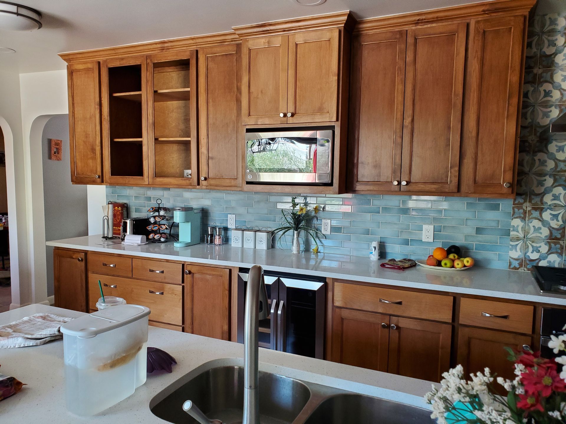 A kitchen with wooden cabinets and a stainless steel sink