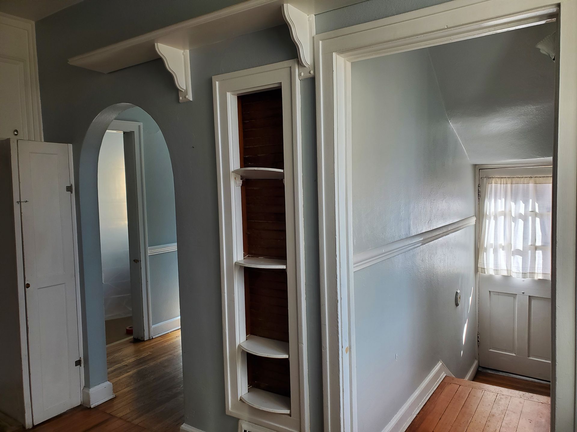 A hallway with a shelf in the middle of it