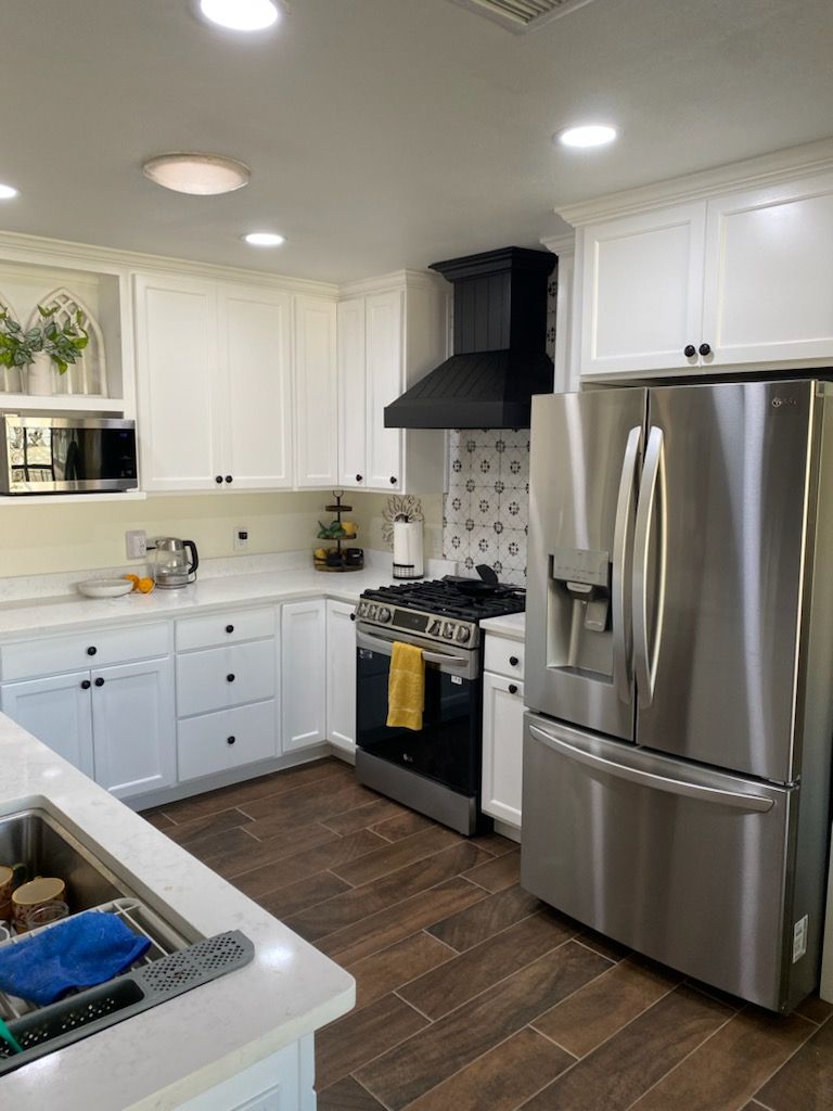 A kitchen with stainless steel appliances and white cabinets.